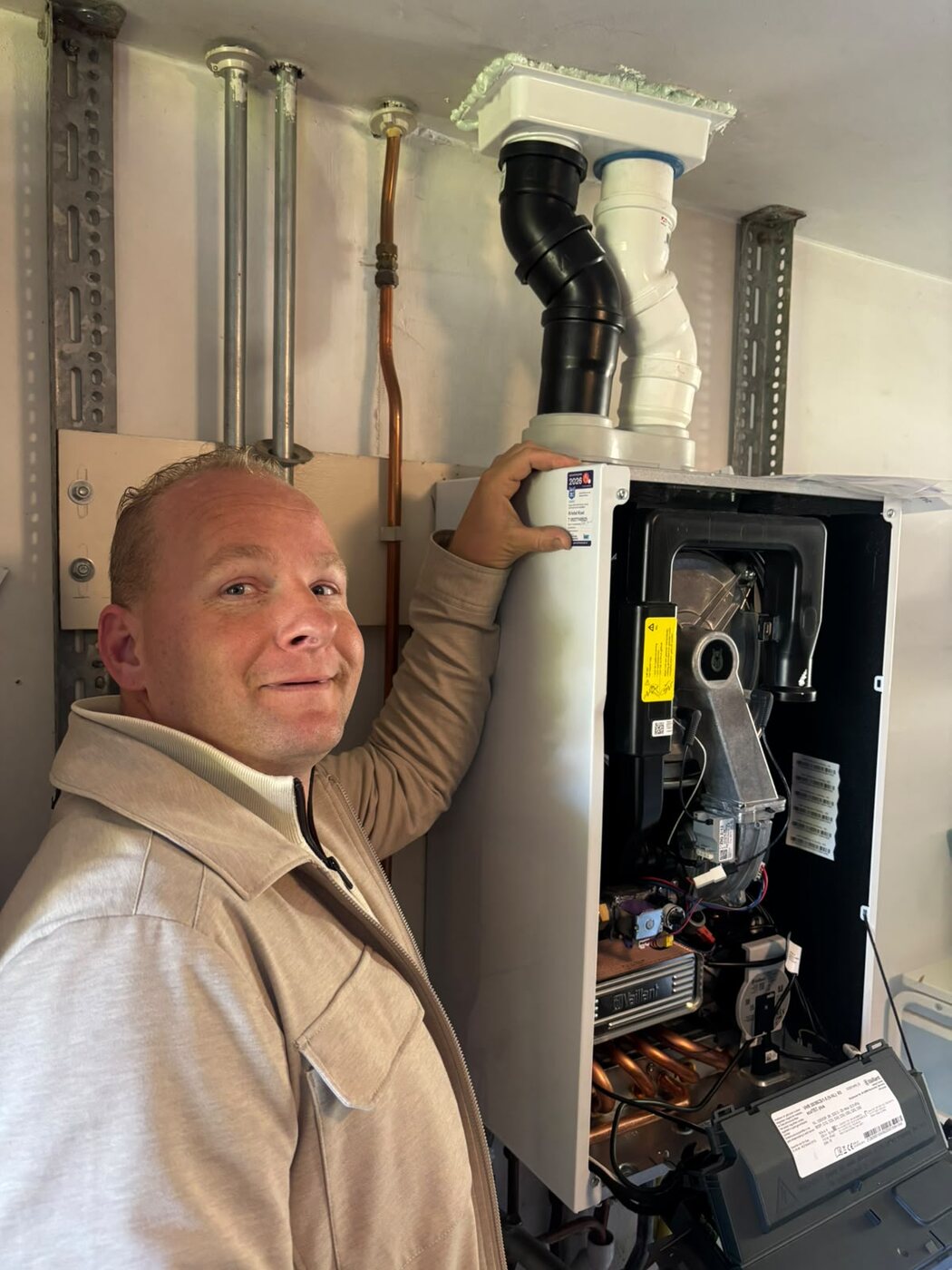 Monteur naast een open cv-installatie in een technische ruimte