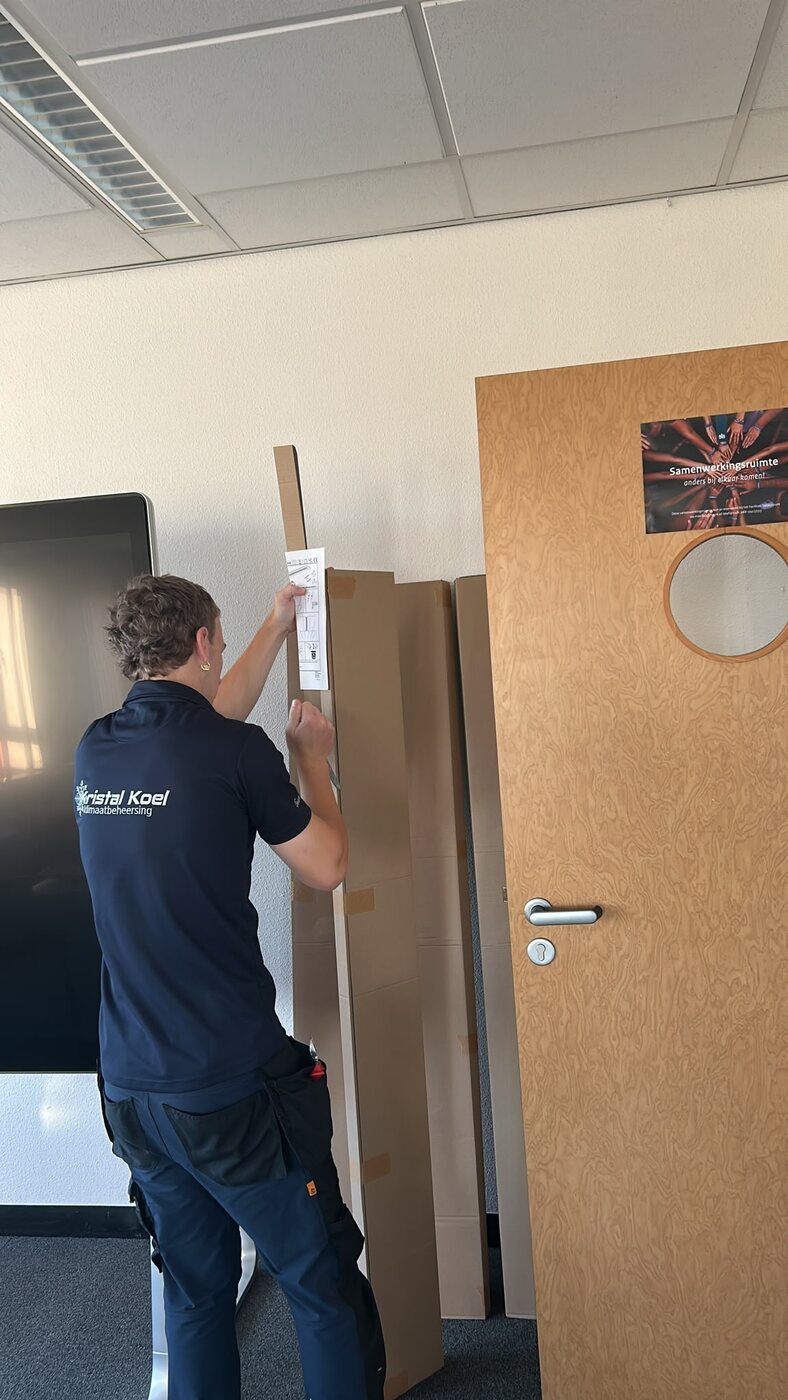 Monteur meet een paneel voor voorbereidend installatiewerk